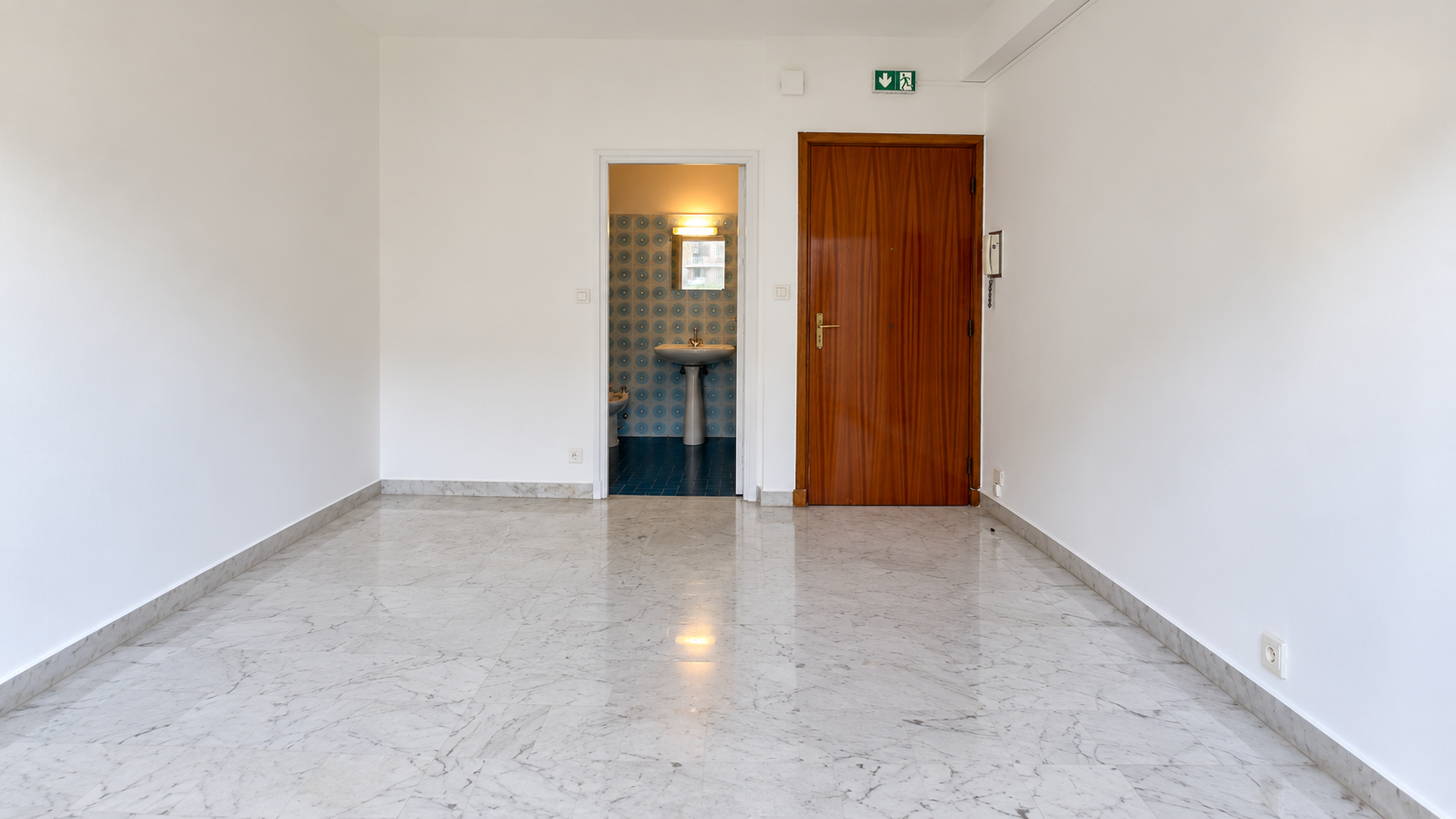 Empty studio viewed towards the entrance and bathroom