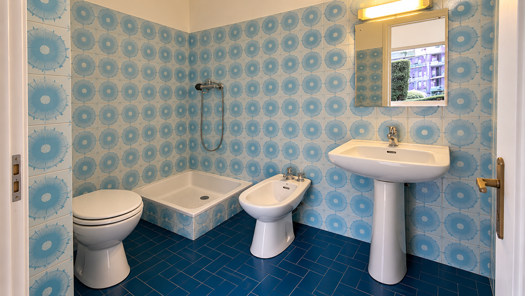 Bathroom with blue tiles and white sanitary fixtures